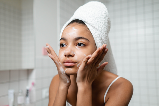 Jeune femme nettoyant son visage avec un savon artisanal naturel, pour une routine beauté douce et respectueuse de la peau.
