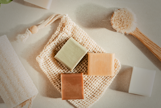 Savons artisanaux avec accessoires de bain écologiques, illustrant une approche durable et zéro déchet pour l’hygiène quotidienne.